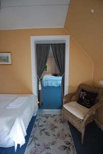 a hotel room with a bed and a chair and a bedroom at Hotell Turistgården i Simrishamn in Simrishamn