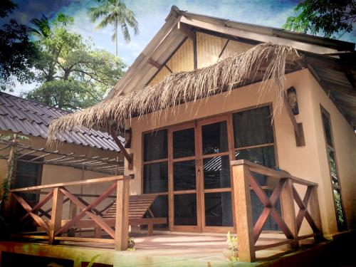 a small house with a thatched roof at Nautilus Right on the Beach - Adult Only - SHA Extra Plus in Ko Lanta