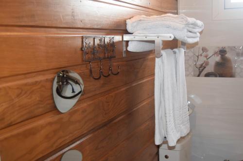 baño con toallas blancas colgadas en una pared de madera en Gîte étoile du matin Grand-bourg de Marie-galante, en Grand-Bourg