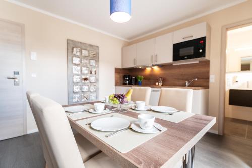 a kitchen and dining room with a table and chairs at AKZENT Apartmenthotel Binz in Binz