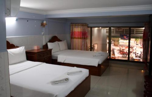 una camera d'albergo con due letti e una finestra di Khmer Village Guesthouse a Phnom Penh