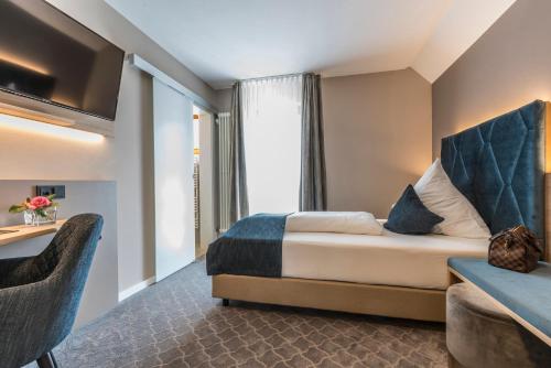 a hotel room with a bed and a window at Hotel Garni Villa Rosengarten in Überlingen