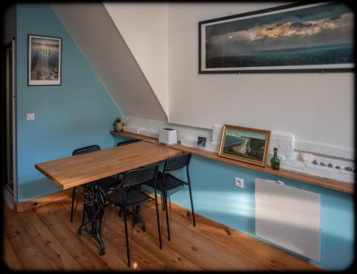 a dining room with a wooden table and chairs at Grand studio duplex proche de la mer in Fécamp