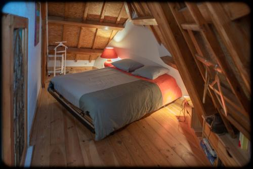 ein Schlafzimmer mit einem Bett und einer Lampe im Dachgeschoss in der Unterkunft Grand studio duplex proche de la mer in Fécamp