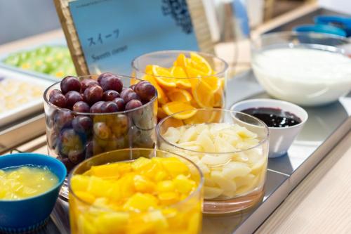 a counter topped with bowls of fruit and other ingredients at Vessel Hotel Campana Susukino in Sapporo