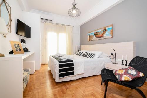 um quarto branco com uma cama e uma cadeira em Lyto by Heloni Apartments em Atenas