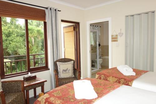 a hotel room with two beds and a window at Cherry Berry Guest House in George