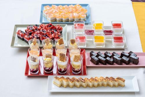 a table topped with trays of different types of desserts at Vessel Inn Sapporo Nakajimakoen in Sapporo