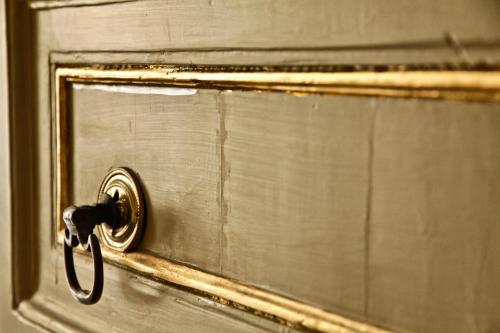 a gold door with a latch on a window at Casa Barone Agnello in Cefalù