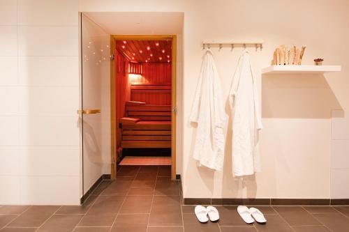 a bathroom with a shower and a pair of shoes at Brauers Landarthotel GmbH in Daun