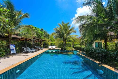a swimming pool in a resort with palm trees at Aonang Oscar Pool Villas - Free Shuttle to Aonang Beach -shared pool - private pool in Ao Nang Beach