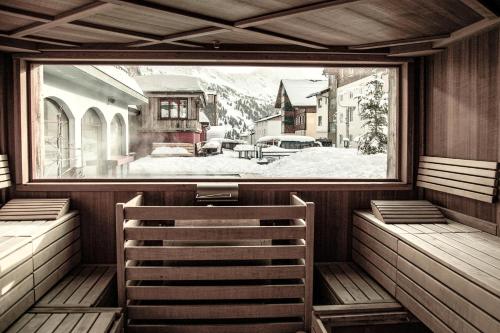a steam room with a view of a snow covered yard at Hotel Rigele Royal Superior in Obertauern