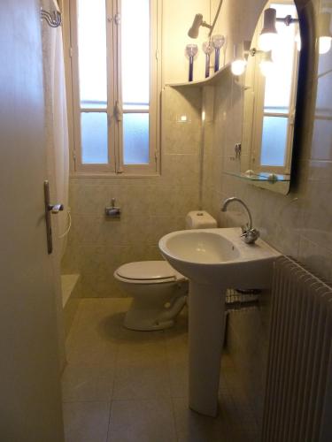a bathroom with a sink and a toilet and a window at Maison Baxter in Prats-de-Mollo-la-Preste