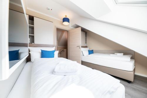 two beds in a room with a staircase at AKZENT Apartmenthotel Binz in Binz
