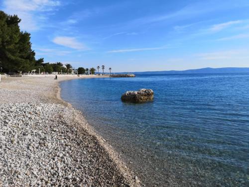 a large rock in the water on a beach at Apartments Malina in Tučepi