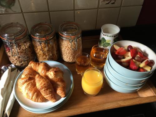 een tafel met een bord gebak en een fruitschaal bij Mays Cottage Bed and Breakfast in Petersfield