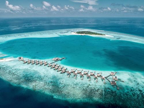 an island with a resort in the middle of the ocean at Angsana Velavaru In-Ocean Villas in Dhaalu Atoll