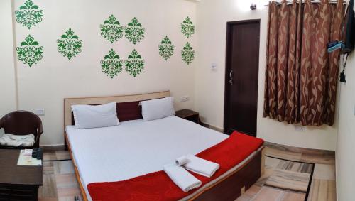 a bedroom with a bed with a red blanket at Madhav Guest House in Jaipur