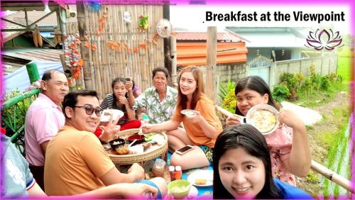 a group of people sitting around a table eating food at Bua Patumma Resort in Mae Sai