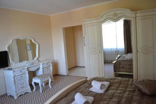 a bedroom with a bed and a dresser and a mirror at Tonal in Mukacheve