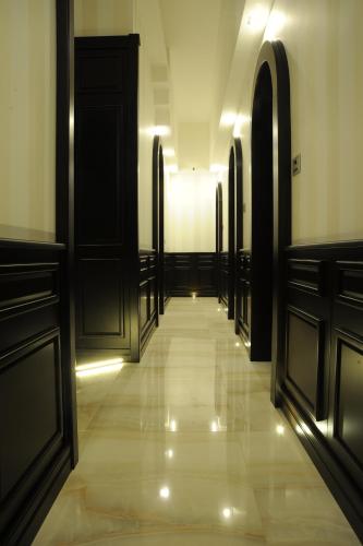 a hallway with black doors and a tile floor at Muro Torto suite - Struttura sanificata giornalmente con ozono e prodotti specifici conformi al Decalogo del Ministero Salute - Personale sottoposto a test sierologico periodicamente in Foggia