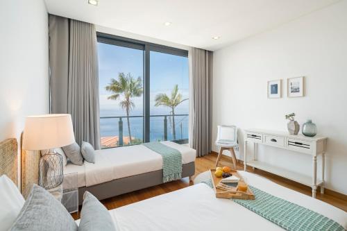 a hotel room with two beds and a large window at Vila Papagaio Verde by An Island Apart in Funchal