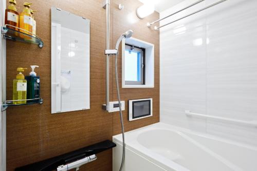 une salle de bain avec une baignoire et un lavabo dans l'établissement Namba 2 bedroom apartment, 1 min to Nippombashi, à Osaka
