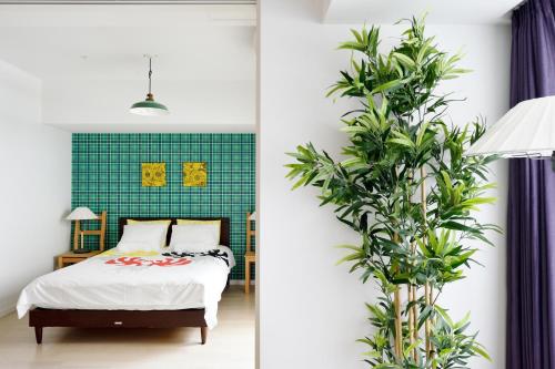 une chambre avec un lit et un mur végétal dans l'établissement Namba 2 bedroom apartment, 1 min to Nippombashi, à Osaka