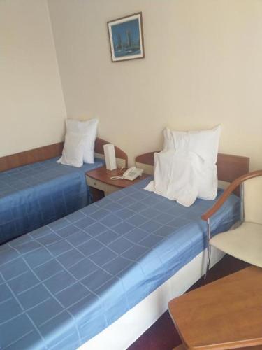 a hotel room with two beds and a telephone at Hotel Doina in Neptun