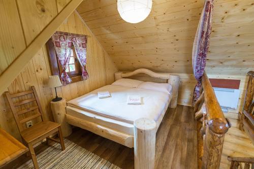 a bedroom with a bed in a log cabin at Ubytovanie Koliba Pacho - Zrub Evka in Prievidza