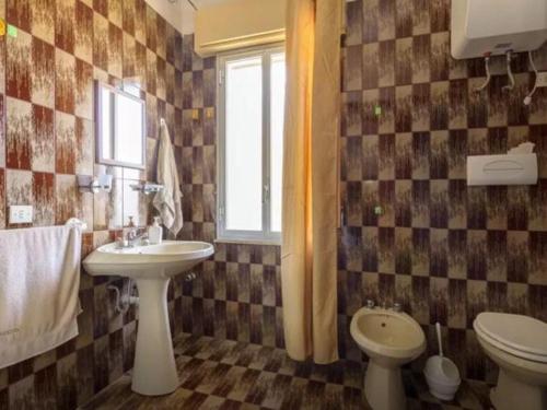 スコペッロにあるLa Maison du Soleilのバスルーム(洗面台、トイレ付)、窓が備わります。