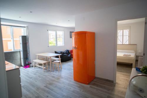 an orange refrigerator in a room with a table at PISO DE DISEÑO A 5 MIN ANDANDO DE LA PLAYA in Valencia