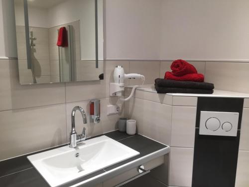 La salle de bains est pourvue d'un lavabo et d'une serviette rouge. dans l'établissement Gasthof Kirschtraum, à Sontra