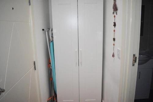 a pair of white cabinets in a room at Lux Apartment in Gatwick in Crawley