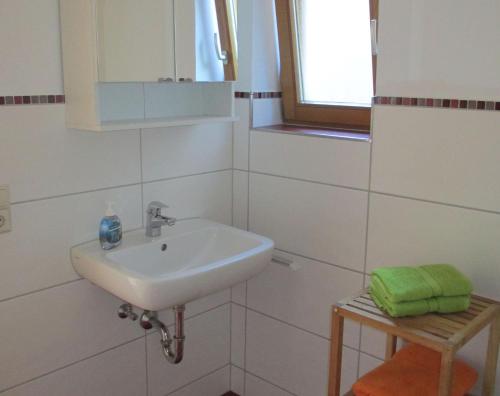 a white bathroom with a sink and a window at Ferienwohnung Maria in Todtmoos