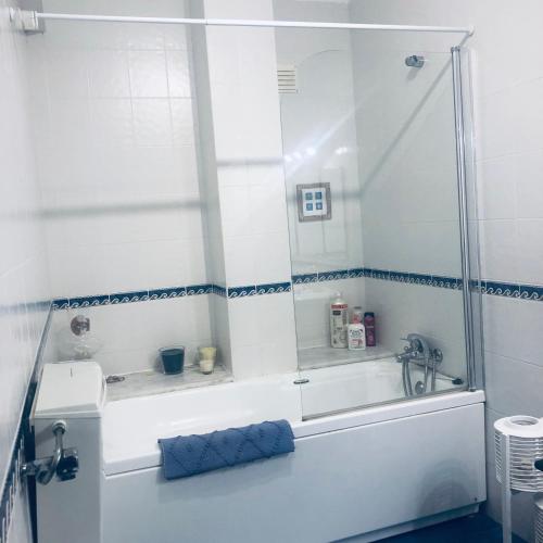 a white bathroom with a tub and a shower at Casa da Aldeia - Guest House in Odiáxere