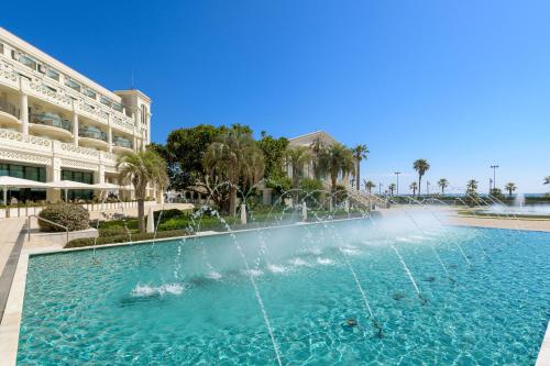 a fountain in a pool in front of a building at Las Arenas Balneario Resort in Valencia