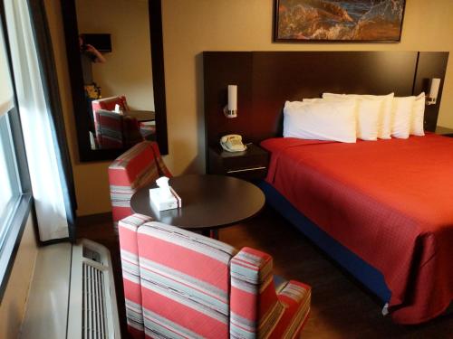 a hotel room with a bed and a table and a chair at Riverside Tower in Pigeon Forge