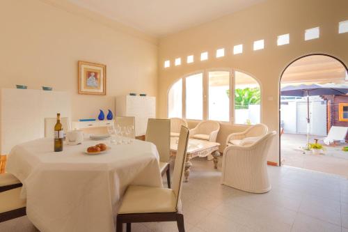 a white dining room with a table and chairs at Casa en Primera Línea de Playa in Oliva