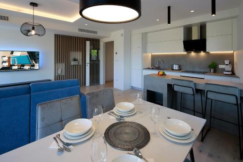 a dining room and kitchen with a table and chairs at MODENA MARIS-heated pool-grill-relax-jacuzzi apartments in Ičići