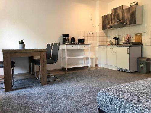 een kamer met een tafel en een keuken met een aanrecht bij Viadrina Rooms & Apartments Frankfurt-Oder am Park im Zentrum in Frankfurt/Oder