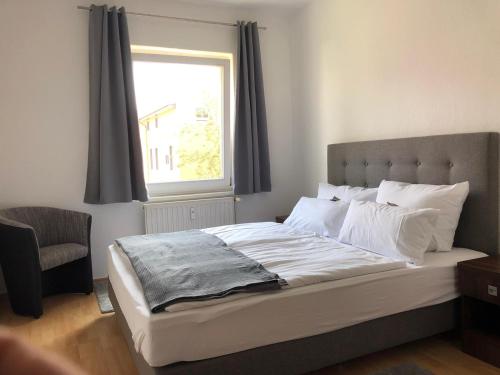 una camera da letto con un grande letto e una finestra di Viadrina Rooms & Apartments Frankfurt-Oder am Park im Zentrum a Francoforte sull'Oder