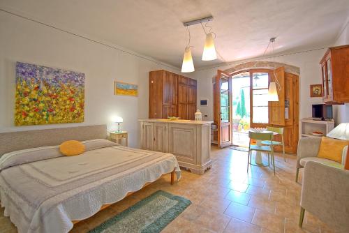 a bedroom with a bed and a living room at Poggiluglio by PosarelliVillas in San Gimignano