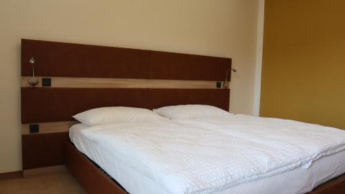 a bedroom with a large bed with a wooden headboard at Wartmannstetterhof in Wartmannstetten