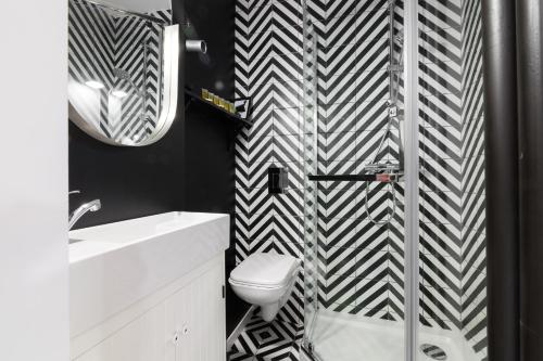 un bagno bianco e nero con servizi igienici e lavandino di Independence Museum Charming Apartment a Varsavia