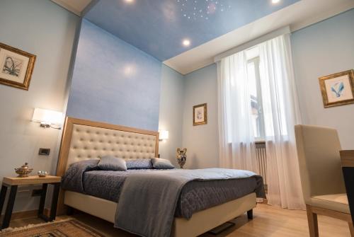 a bedroom with a bed with blue walls and a window at Brunelli B&B in Assisi