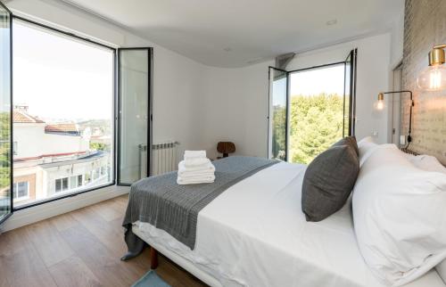 a bedroom with a large bed and large windows at Plaza de España Skyline in Madrid