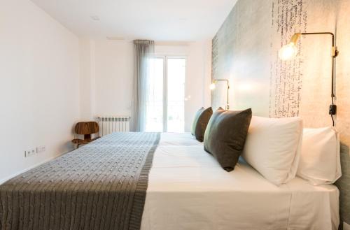 a bedroom with a large white bed with pillows at Plaza de España Skyline in Madrid