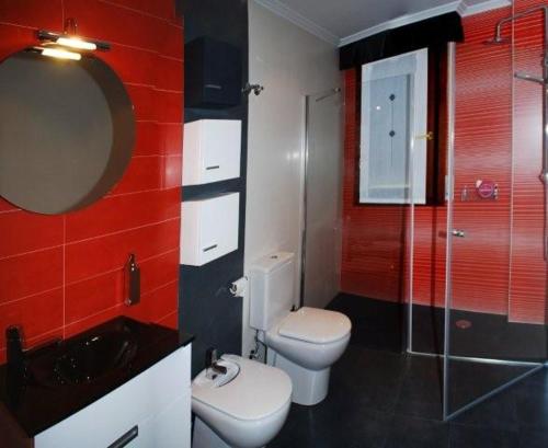 a bathroom with a toilet and a sink and a mirror at El Encinedo in Genevilla