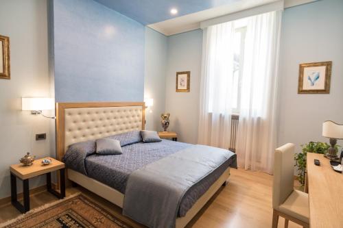 a bedroom with a bed and a blue wall at Brunelli B&B in Assisi